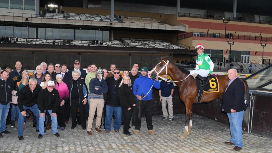 Alex Zacney (front row, fourth from right) poses with Maximus Mischief in the Remsen Stakes winner's circle.